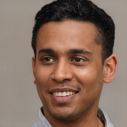 Joyful latino young-adult male with short  black hair and brown eyes