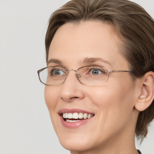 Joyful white adult female with medium  brown hair and grey eyes