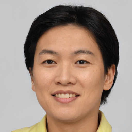 Joyful asian adult female with short  brown hair and brown eyes