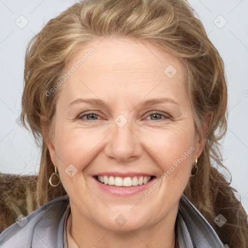 Joyful white adult female with medium  brown hair and blue eyes