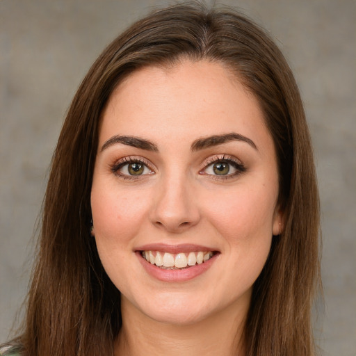 Joyful white young-adult female with long  brown hair and green eyes