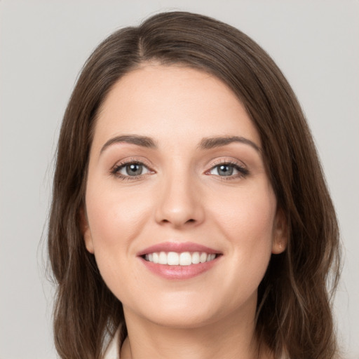 Joyful white young-adult female with long  brown hair and grey eyes