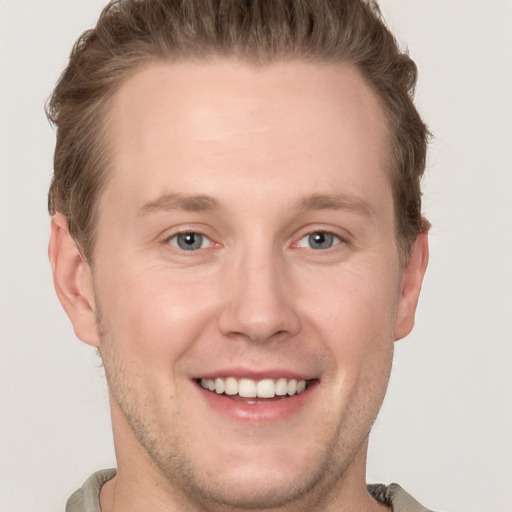 Joyful white adult male with short  brown hair and grey eyes