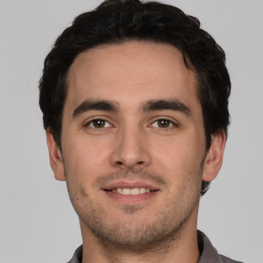Joyful white young-adult male with short  black hair and brown eyes
