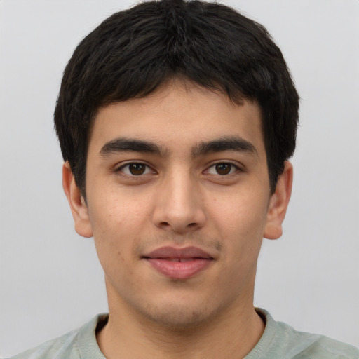 Joyful latino young-adult male with short  brown hair and brown eyes