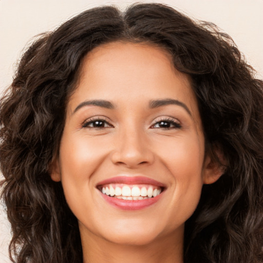 Joyful white young-adult female with long  brown hair and brown eyes