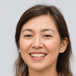 Joyful white adult female with long  brown hair and brown eyes