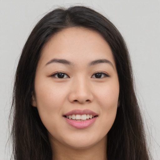 Joyful asian young-adult female with long  brown hair and brown eyes