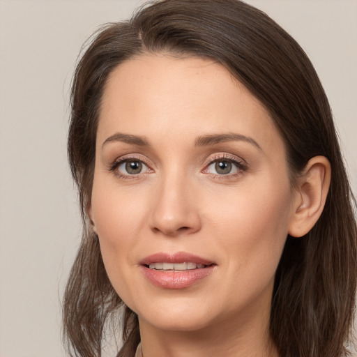 Joyful white young-adult female with long  brown hair and grey eyes