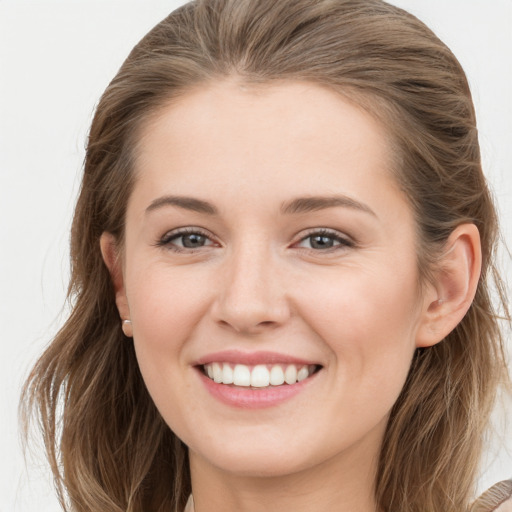 Joyful white young-adult female with long  brown hair and grey eyes