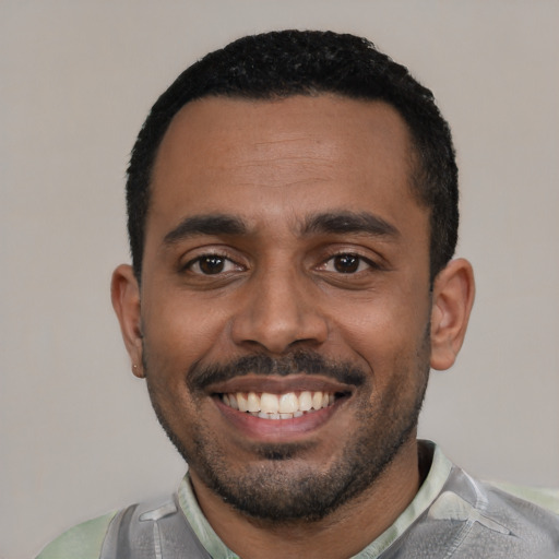 Joyful black young-adult male with short  black hair and brown eyes