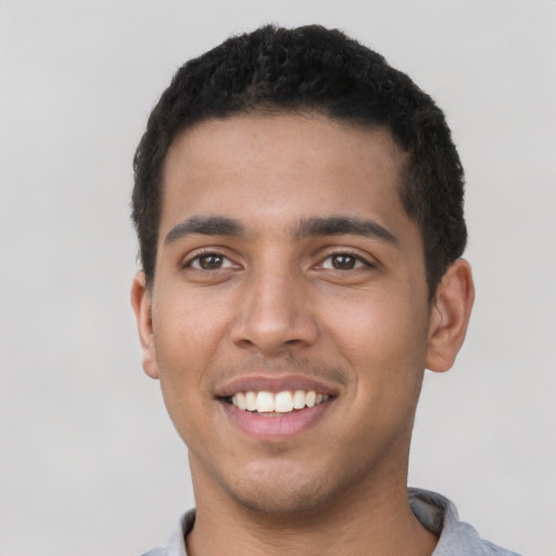 Joyful latino young-adult male with short  black hair and brown eyes