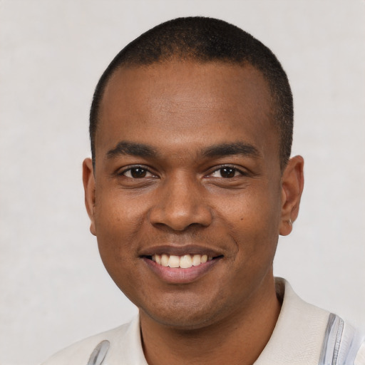 Joyful black young-adult male with short  brown hair and brown eyes