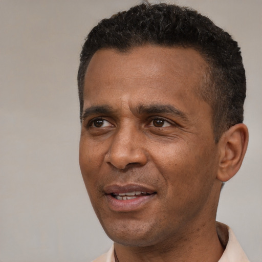 Joyful black adult male with short  black hair and brown eyes