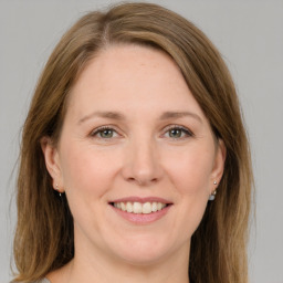 Joyful white adult female with long  brown hair and grey eyes