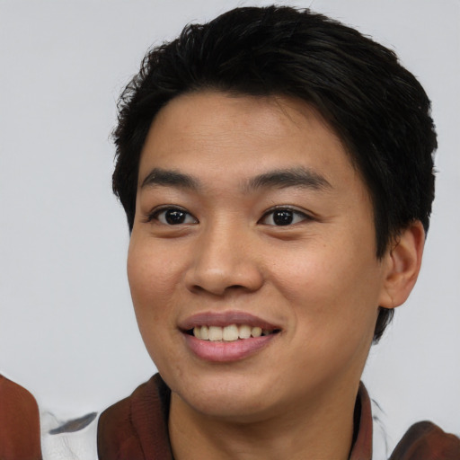 Joyful asian young-adult male with short  brown hair and brown eyes