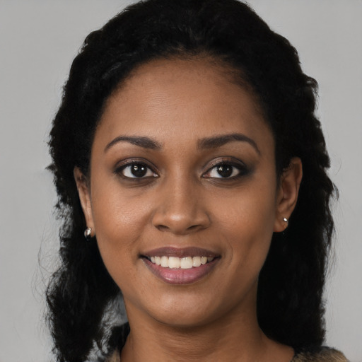Joyful black young-adult female with long  black hair and brown eyes