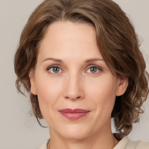 Joyful white adult female with medium  brown hair and grey eyes