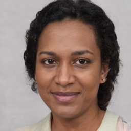 Joyful black adult female with medium  brown hair and brown eyes