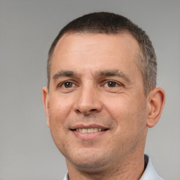 Joyful white adult male with short  brown hair and brown eyes