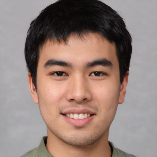 Joyful asian young-adult male with short  brown hair and brown eyes