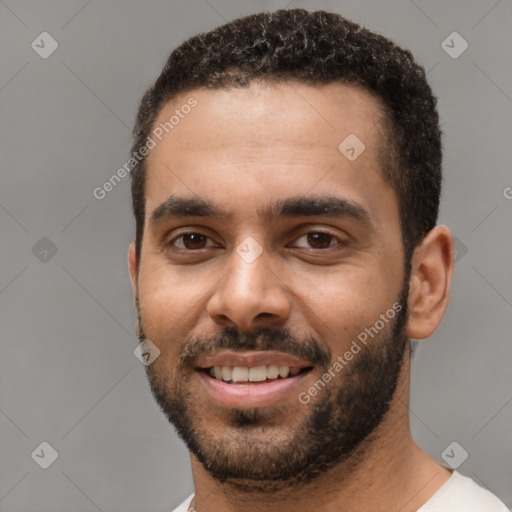 Joyful black young-adult male with short  black hair and brown eyes