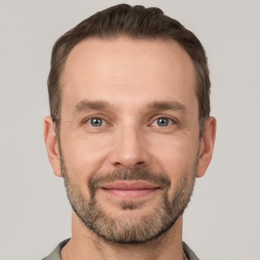 Joyful white adult male with short  brown hair and grey eyes