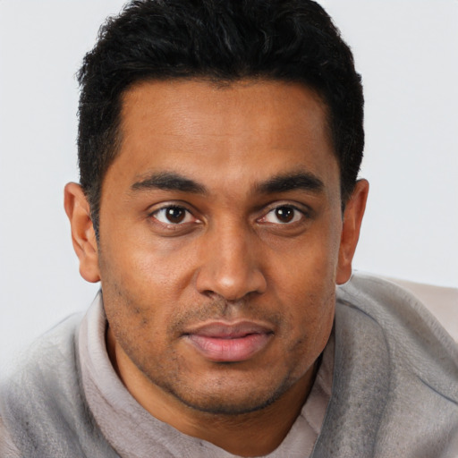 Joyful black young-adult male with short  black hair and brown eyes