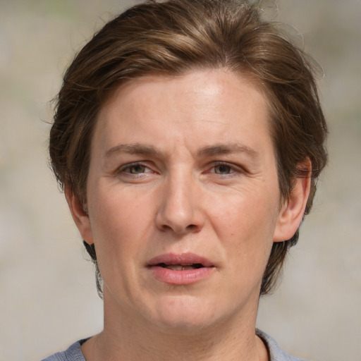 Joyful white adult female with medium  brown hair and blue eyes