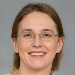 Joyful white adult female with medium  brown hair and blue eyes