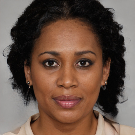 Joyful black adult female with medium  brown hair and brown eyes