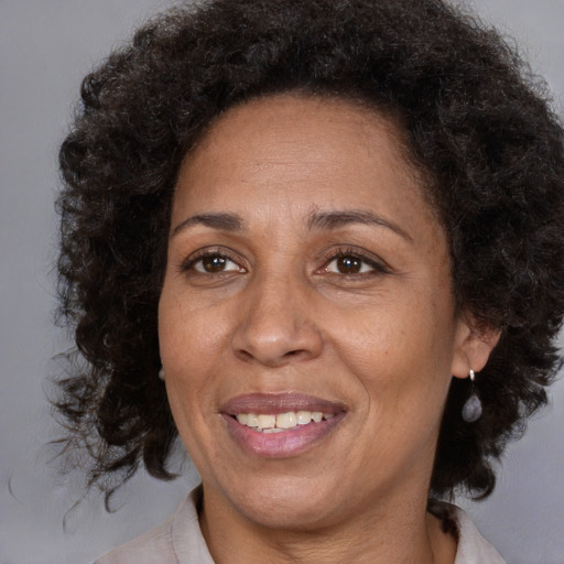 Joyful black adult female with medium  brown hair and brown eyes