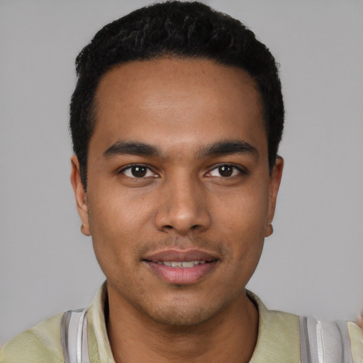 Joyful latino young-adult male with short  black hair and brown eyes