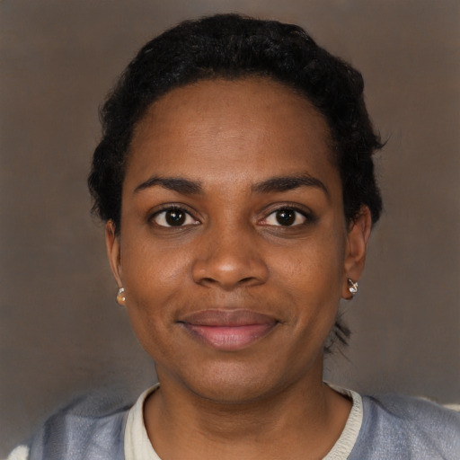 Joyful black young-adult female with short  black hair and brown eyes
