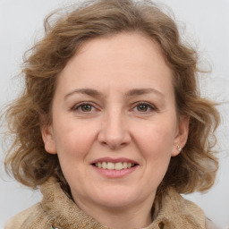 Joyful white adult female with medium  brown hair and grey eyes