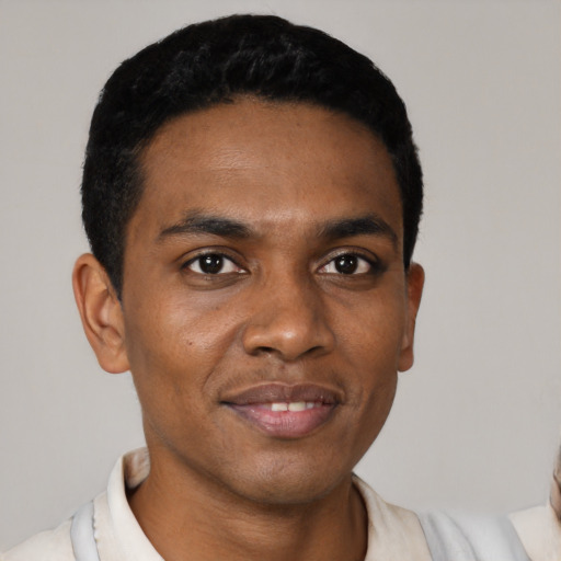 Joyful black young-adult male with short  black hair and brown eyes