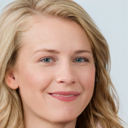 Joyful white young-adult female with long  brown hair and blue eyes