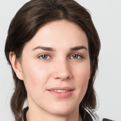 Joyful white young-adult female with medium  brown hair and grey eyes