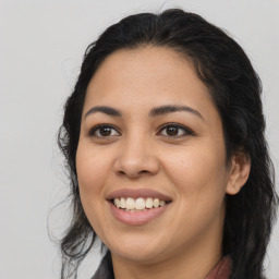 Joyful latino young-adult female with long  brown hair and brown eyes