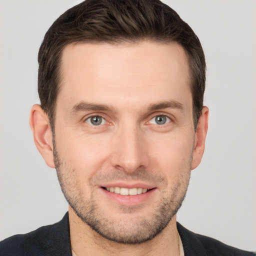 Joyful white young-adult male with short  brown hair and grey eyes