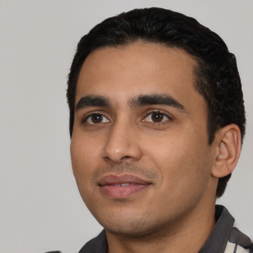 Joyful latino young-adult male with short  black hair and brown eyes