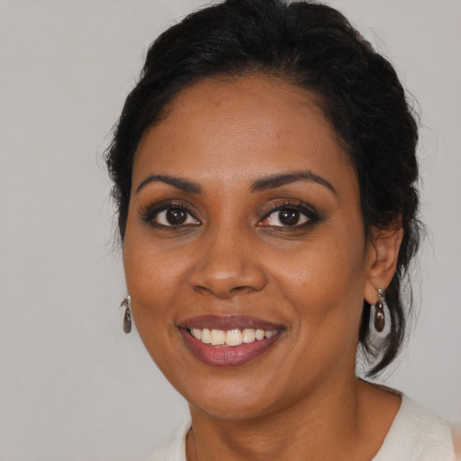 Joyful black young-adult female with medium  brown hair and brown eyes