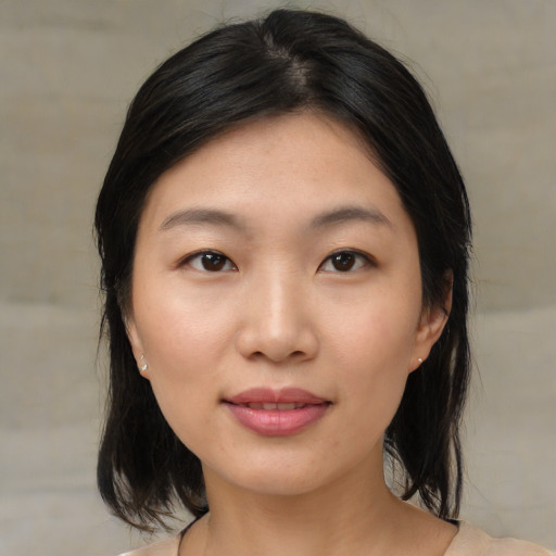 Joyful asian young-adult female with medium  black hair and brown eyes