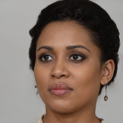 Joyful black young-adult female with medium  black hair and brown eyes
