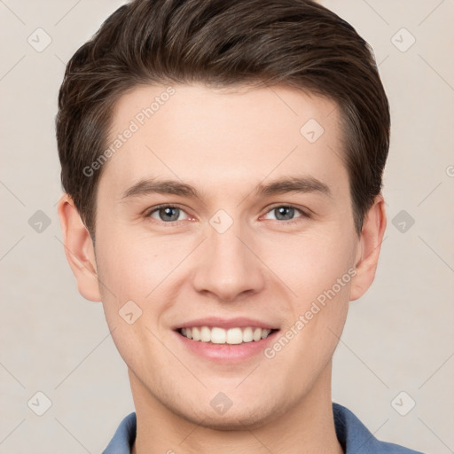 Joyful white young-adult male with short  brown hair and grey eyes