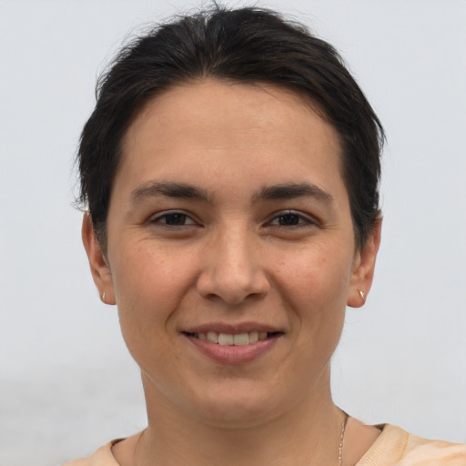 Joyful white young-adult female with short  brown hair and brown eyes