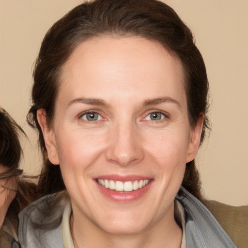 Joyful white adult female with medium  brown hair and brown eyes