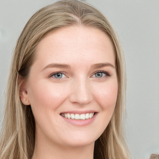 Joyful white young-adult female with long  brown hair and blue eyes