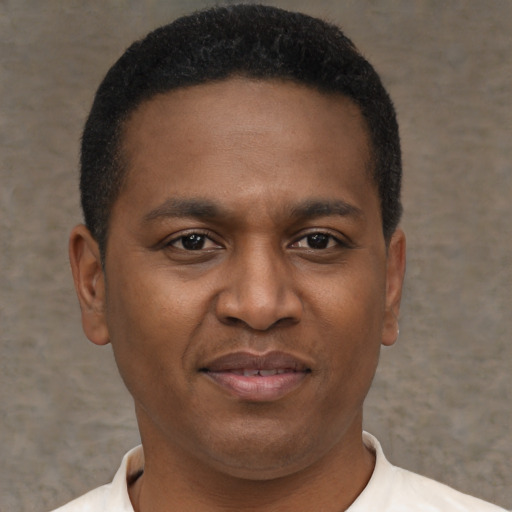 Joyful black young-adult male with short  brown hair and brown eyes