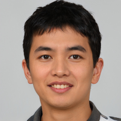 Joyful asian young-adult male with short  black hair and brown eyes